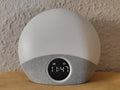 HarborHearth Sunrise Alarm Clock — warm amber glow on light grey fabric base