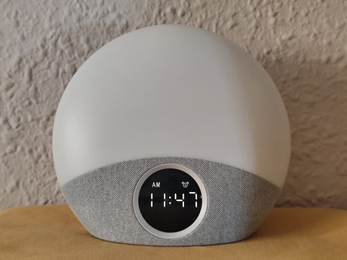 HarborHearth Sunrise Alarm Clock — warm amber glow on light grey fabric base